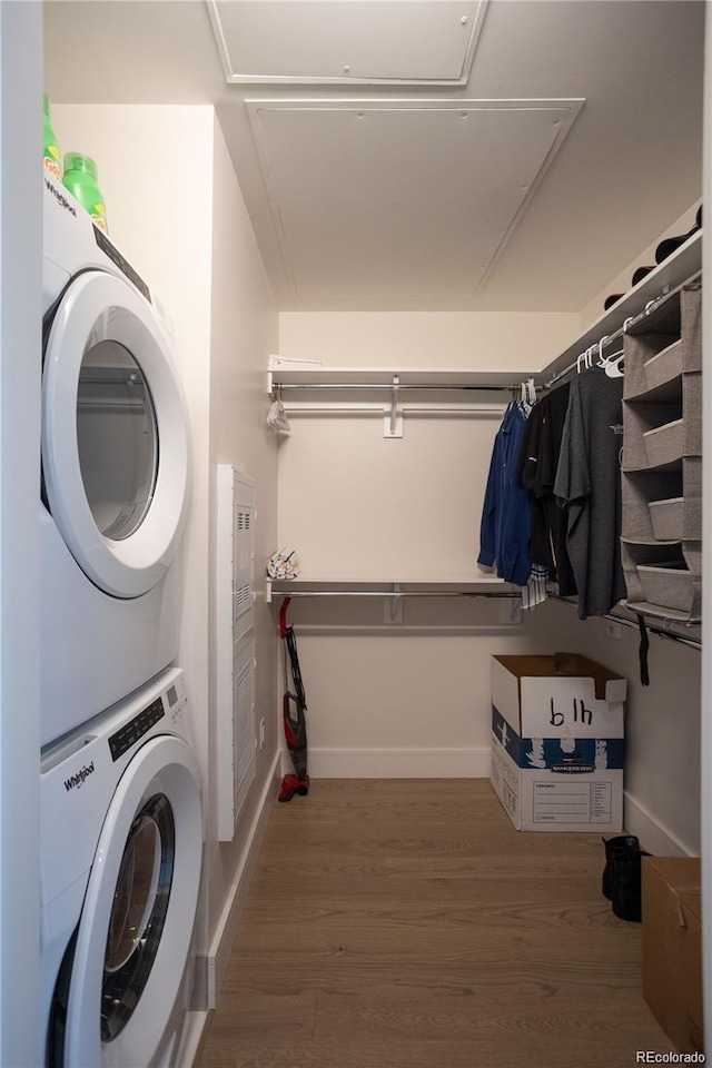 clothes washing area featuring stacked washer and clothes dryer and dark hardwood / wood-style floors