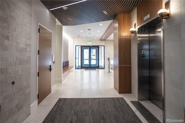 corridor with french doors, light tile flooring, and elevator