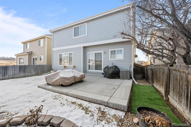 snow covered rear of property with a patio and central air condition unit