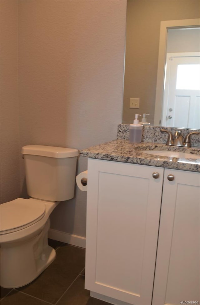 bathroom with tile patterned flooring, vanity, and toilet