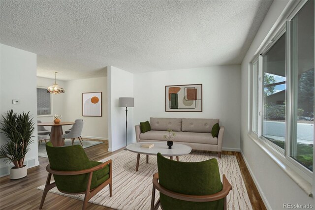 7552 Garland St, Arvada, CO 80005 - living area with wood finished floors, a textured ceiling, a chandelier, and baseboards