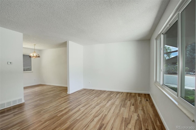 7552 Garland St, Arvada, CO 80005 - unfurnished room with a chandelier, wood finished floors, a textured ceiling, and baseboards