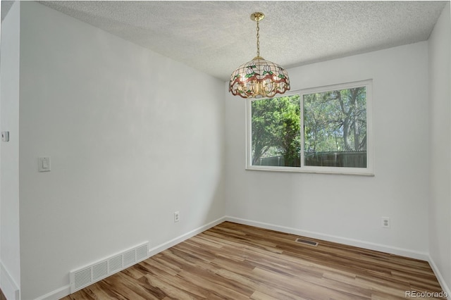 7552 Garland St, Arvada, CO 80005 - spare room with wood finished floors, a textured ceiling, and baseboards