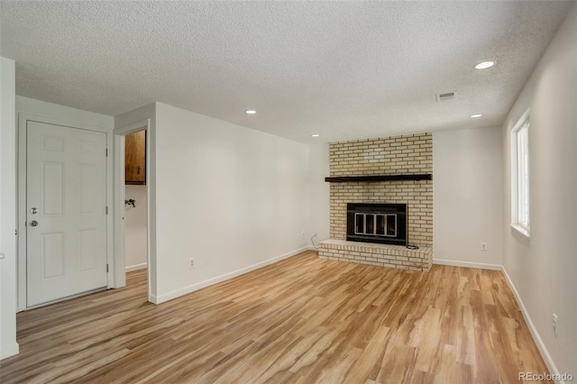 7552 Garland St, Arvada, CO 80005 - unfurnished living room featuring a textured ceiling, light wood finished floors, recessed lighting, baseboards, and a fireplace
