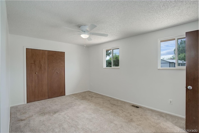 7552 Garland St, Arvada, CO 80005 - unfurnished bedroom featuring multiple windows, carpet flooring, a closet, a textured ceiling, and ceiling fan