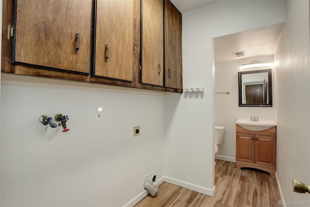 7552 Garland St, Arvada, CO 80005 - laundry room featuring electric dryer hookup, light wood-type flooring, cabinet space, and baseboards