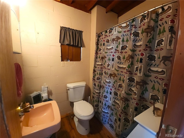 bathroom with hardwood / wood-style flooring, sink, curtained shower, and toilet