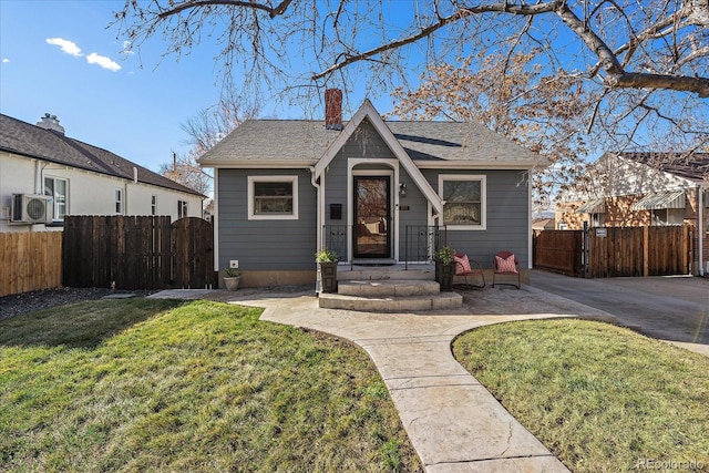 view of front of property featuring roof with shingles, a chimney, fence, and a front yard