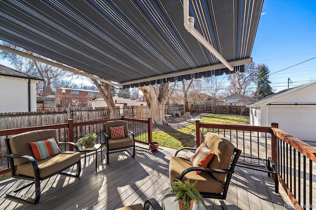 wooden terrace with an outdoor structure and a fenced backyard