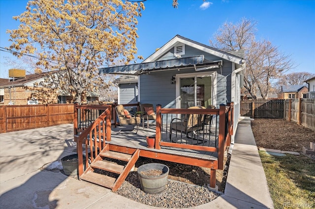 back of house with a fenced backyard and a deck