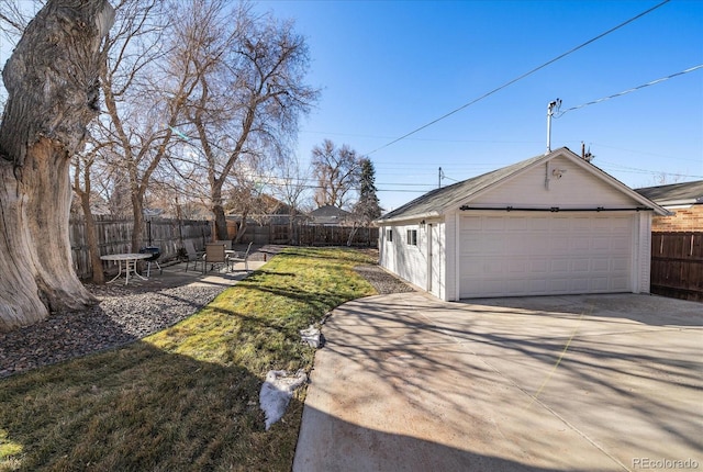 view of yard featuring a garage, fence, a patio, and an outdoor structure