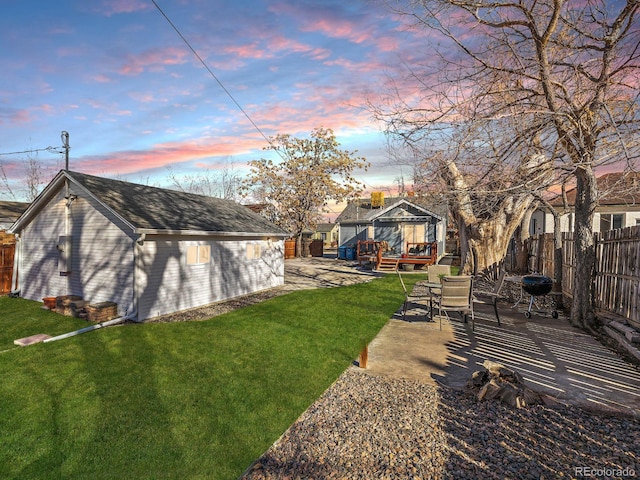 view of yard with fence, an outbuilding, a patio, and a wooden deck