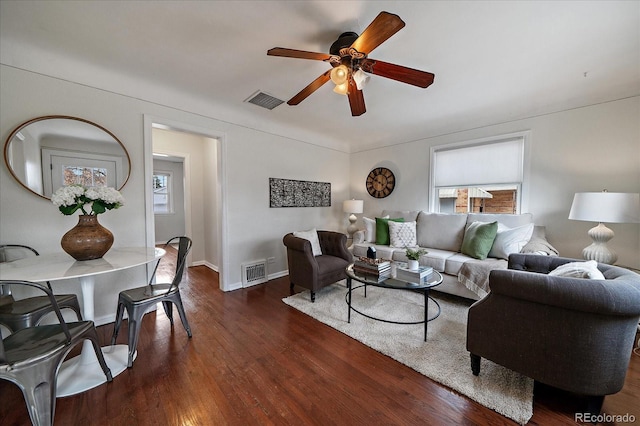 living area with a ceiling fan, dark wood-style flooring, visible vents, and baseboards