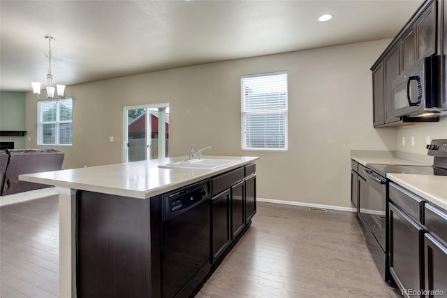 467 S 36th Ave, Brighton, CO 80601 - kitchen featuring black appliances, a sink, hardwood / wood-style flooring, open floor plan, and light countertops
