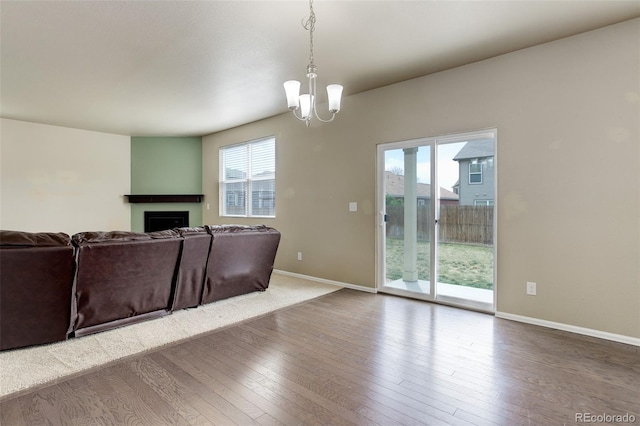 467 S 36th Ave, Brighton, CO 80601 - living area featuring a fireplace, a chandelier, wood-type flooring, and baseboards