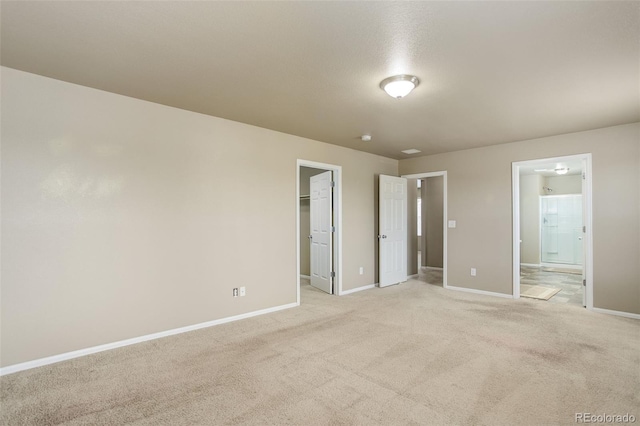467 S 36th Ave, Brighton, CO 80601 - unfurnished bedroom with baseboards, light carpet, a walk in closet, ensuite bath, and a closet