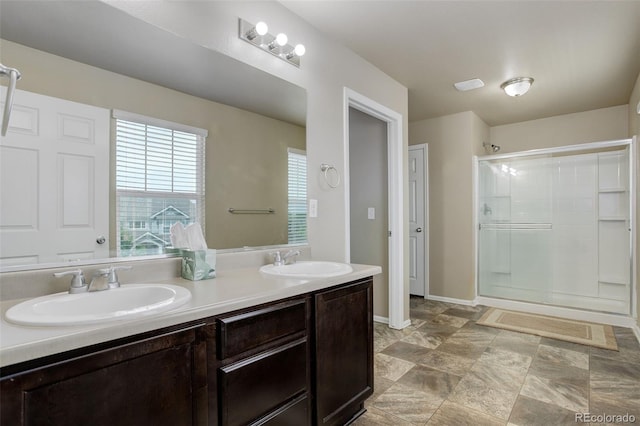 467 S 36th Ave, Brighton, CO 80601 - bathroom featuring a shower stall, double vanity, and baseboards