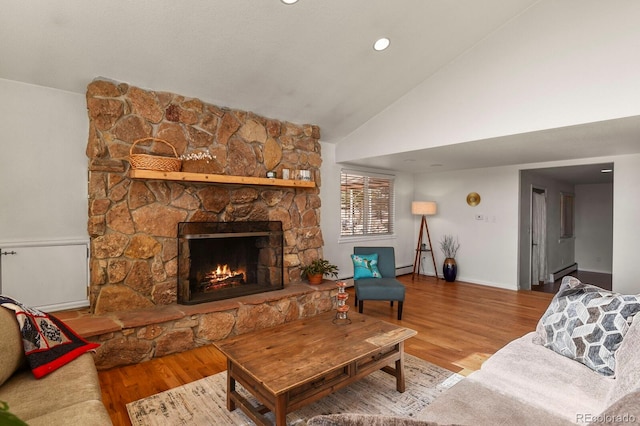 living room featuring a fireplace, hardwood / wood-style flooring, and high vaulted ceiling