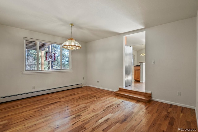 unfurnished dining area with hardwood / wood-style floors, a chandelier, and a baseboard radiator