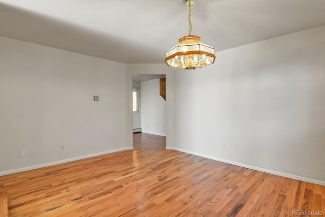 28730 Mountain View Rd, Conifer, CO 80433 - spare room with light wood-style floors, a chandelier, a baseboard heating unit, and baseboards