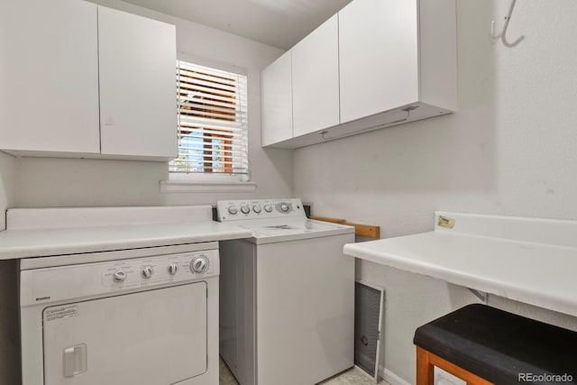 clothes washing area with washer / dryer and cabinets