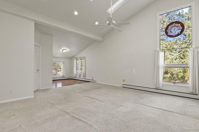 spare room with lofted ceiling with skylight, ceiling fan, a baseboard heating unit, and carpet floors