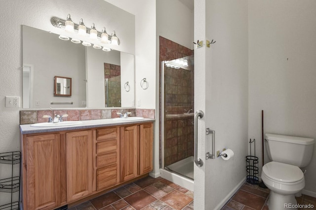 bathroom featuring vanity, toilet, and a shower with shower door