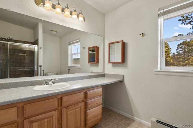 bathroom featuring vanity, toilet, a wealth of natural light, and a baseboard radiator