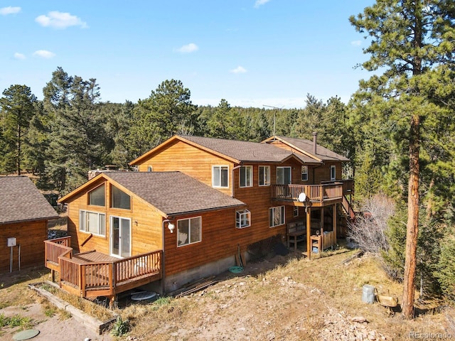 28730 Mountain View Rd, Conifer, CO 80433 - rear view of house with a deck, a shingled roof, and a view of trees