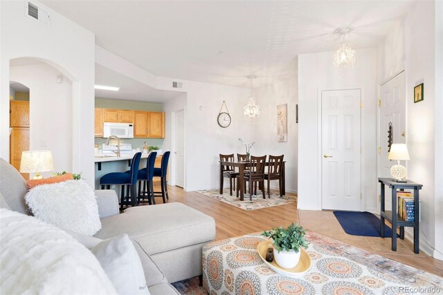 5735 N Genoa Way Unit 11-205, Aurora, CO 80019 - living area with visible vents, arched walkways, and an inviting chandelier