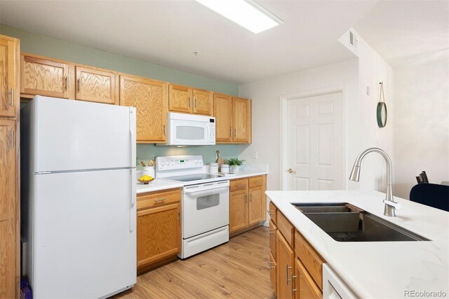 5735 N Genoa Way Unit 11-205, Aurora, CO 80019 - kitchen featuring white appliances, light wood-type flooring, light countertops, and a sink