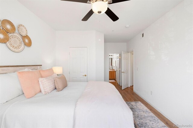 5735 N Genoa Way Unit 11-205, Aurora, CO 80019 - bedroom with visible vents, connected bathroom, a ceiling fan, and light wood-style floors