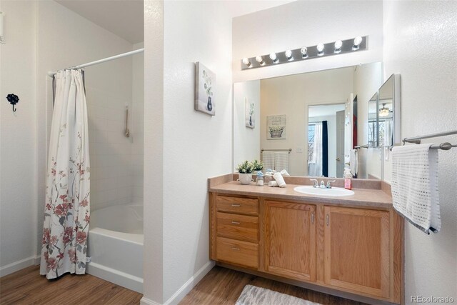 5735 N Genoa Way Unit 11-205, Aurora, CO 80019 - full bath with shower / bath combination with curtain, vanity, baseboards, and wood finished floors