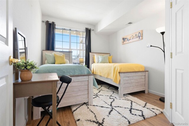 5735 N Genoa Way Unit 11-205, Aurora, CO 80019 - bedroom featuring wood finished floors, visible vents, and baseboards