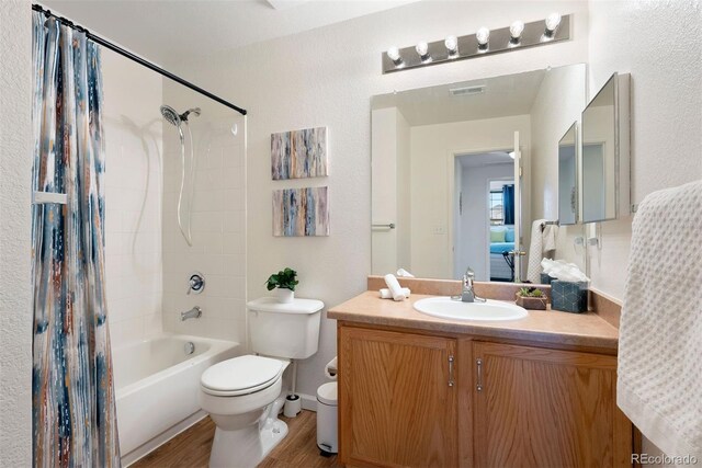 5735 N Genoa Way Unit 11-205, Aurora, CO 80019 - bathroom featuring vanity, wood finished floors, shower / bathtub combination with curtain, visible vents, and toilet