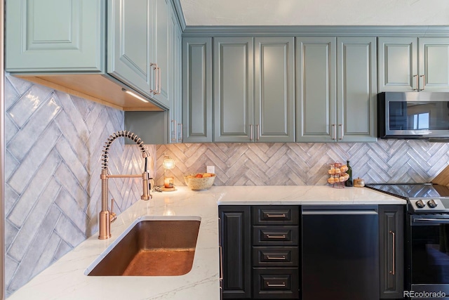 kitchen with sink, light stone counters, appliances with stainless steel finishes, and decorative backsplash