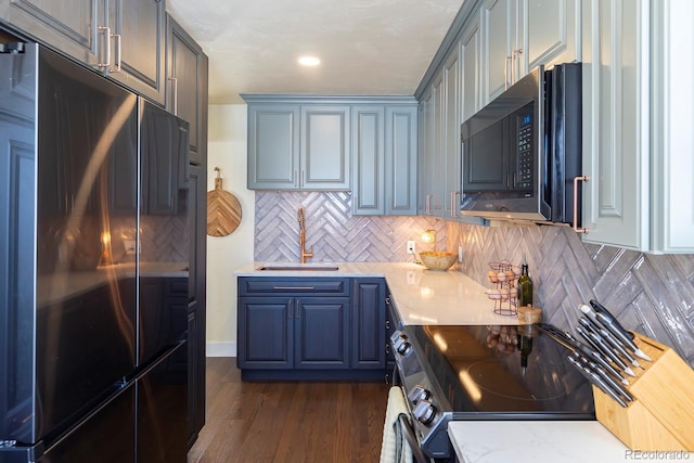 kitchen with fridge, sink, dark hardwood / wood-style flooring, stainless steel electric stove, and backsplash