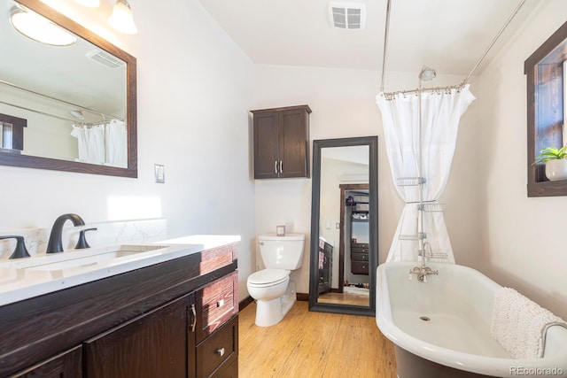 full bathroom featuring wood-type flooring, toilet, vanity, and shower / tub combo with curtain