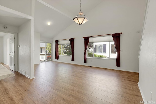 unfurnished living room with high vaulted ceiling, light wood-type flooring, and baseboards