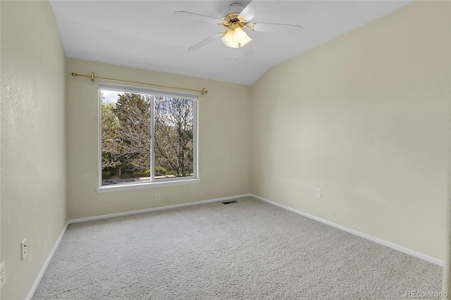 carpeted spare room featuring ceiling fan and baseboards