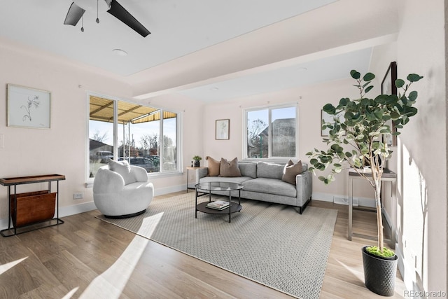 living room with ceiling fan, plenty of natural light, light hardwood / wood-style floors, and beamed ceiling