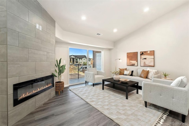 living area featuring visible vents, wood finished floors, a fireplace, high vaulted ceiling, and recessed lighting