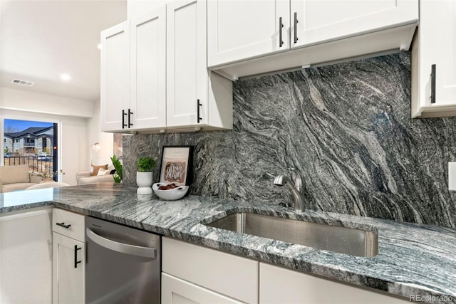 kitchen featuring tasteful backsplash, white cabinets, and a sink