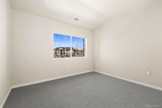 carpeted empty room featuring visible vents, vaulted ceiling, and baseboards