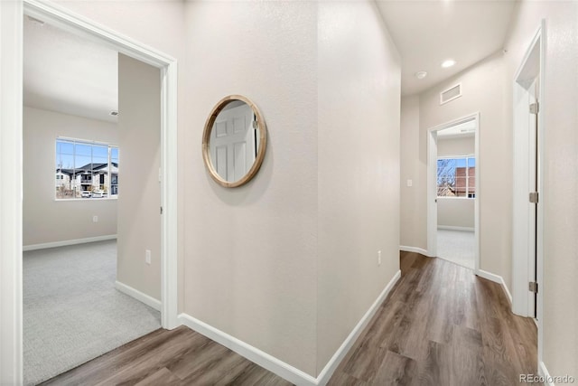 hall with recessed lighting, visible vents, baseboards, and wood finished floors