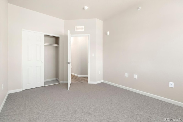 unfurnished bedroom with a closet, carpet flooring, visible vents, and baseboards