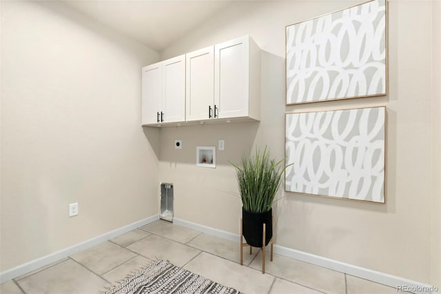 clothes washing area with hookup for a washing machine, cabinet space, hookup for an electric dryer, light tile patterned flooring, and baseboards