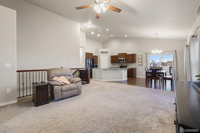 carpeted living room featuring ceiling fan with notable chandelier and high vaulted ceiling