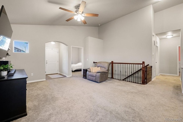 sitting room with ceiling fan, light colored carpet, and high vaulted ceiling