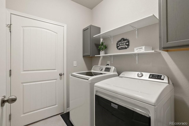 laundry area with cabinets, light tile patterned floors, and washer and dryer